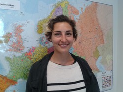 Maria aus Österreich steht vor einer großen Weltkarte im International Office.