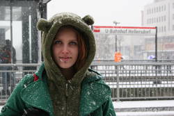 Spela aus Slowenien steht an einer verschneiten Haltestelle im winterlichen Berlin.