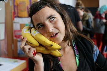 International Day 2015: Informationstisch zum Buddy Programm. Auf dem Bild benutzt eine Frau einen Bananenstrauß als Telefon.