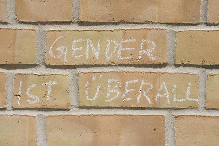Mit Kreide ist an eine Hauswand geschrieben "Gender ist überall"