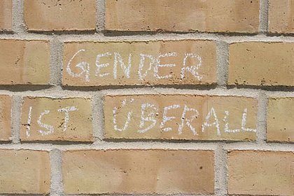 Mit Kreide ist an eine Hauswand geschrieben "Gender ist überall"