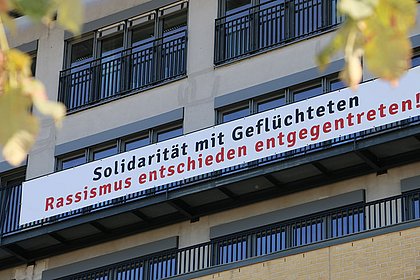 Banner an der Hausfront der ASH Berlin: "Solidarität mit Geflüchtete. Rassismus entschieden entgegentreten!