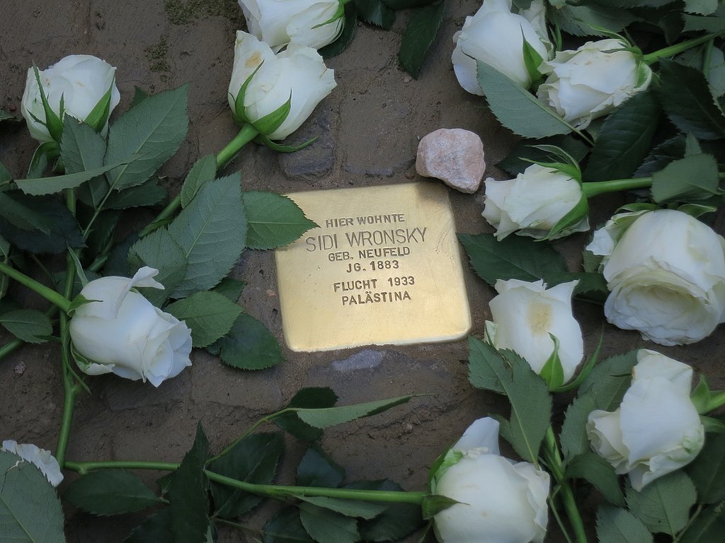 Stolperstein von Sidi Wronsky mit weißen Rosen