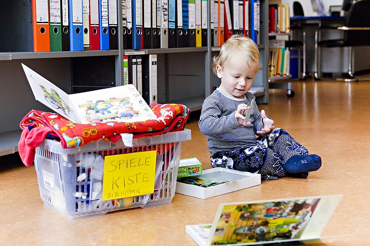 Kind spielt in Universitätsbibliothek - Studieren mit Kind