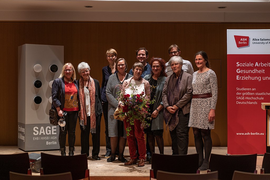 Preisträgerin Adrienne Chambon mit weiteren Personen auf der Bühne im Audimax der ASH Berlin