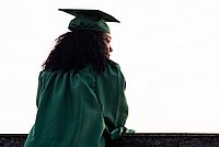 Nach rechts schauende Person mit Doktorhut, von hinten fotografiert.