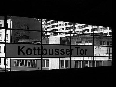 Zu sehen ist ein Schild der U-Bahn Station Kottbusser Tor in schwarz-weiß