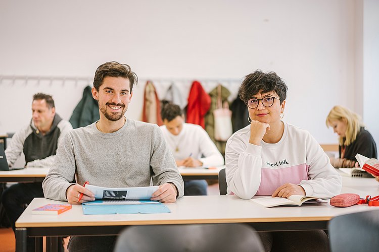 Auf dem Foto sind Studierende der ASH Berlin zu sehen, die in einem Seminarraum sitzen und arbeiten.