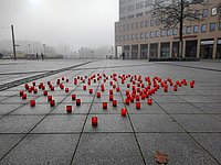 129 brennende Kerzen stehen auf dem Platz vor dem Marzahn-Hellersdorfer Rathaus