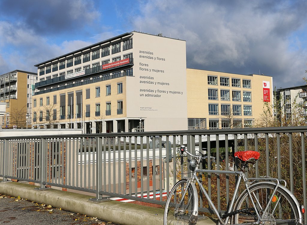 Foto von der Südfassade der ASH Berlin mit dem Gedicht "avenidas" von Eugen Gomringer