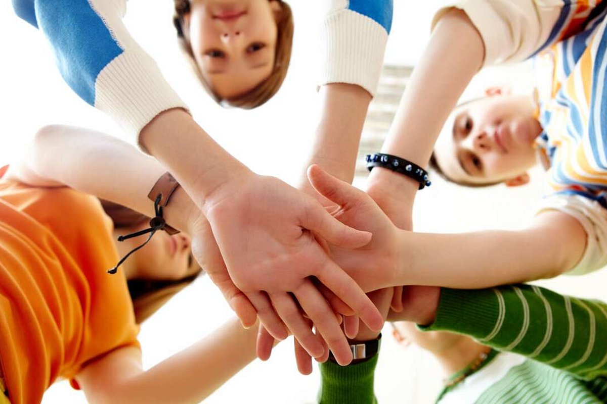 Gruppe von Menschen halten Hände übereinander