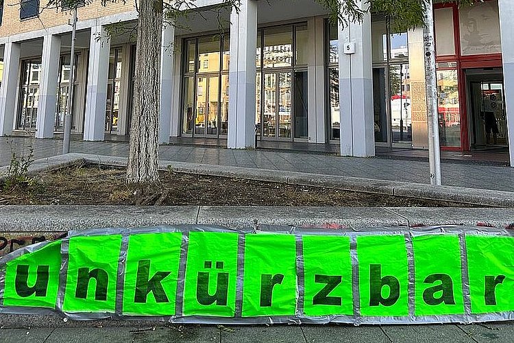 Plakat mit der Aufschrift "ASH unkürzbar" vor dem Haupteingang der ASH Berlin