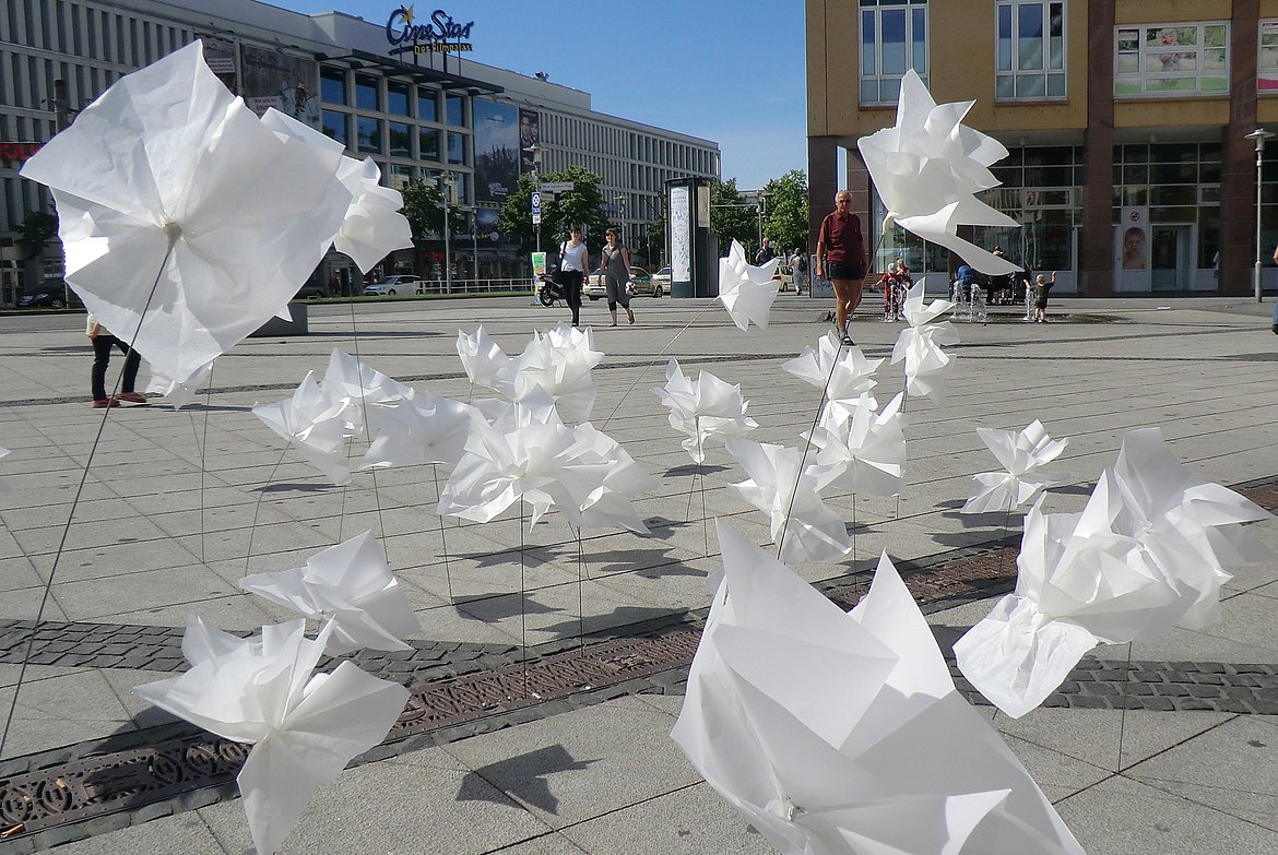 Auf dem Foto ist eine künstlerische Installation zu sehen. Auf dem Alice-Salomon-Platz wurden Blumen aus Papier installiert. 