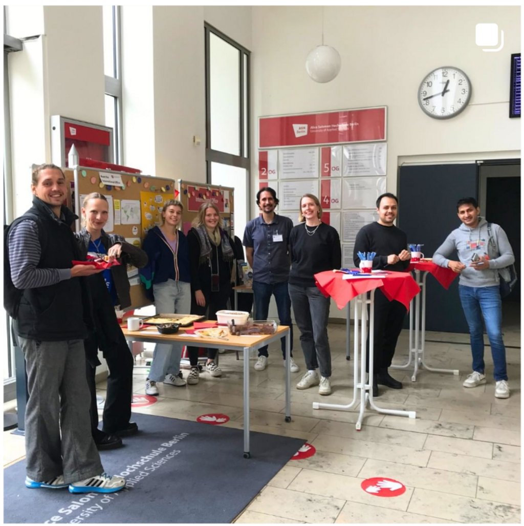 Informationsstand im Foyer mit Mitarbeitenden des International Office, Studierenden und ehemaligen Outgoing-Studierenden