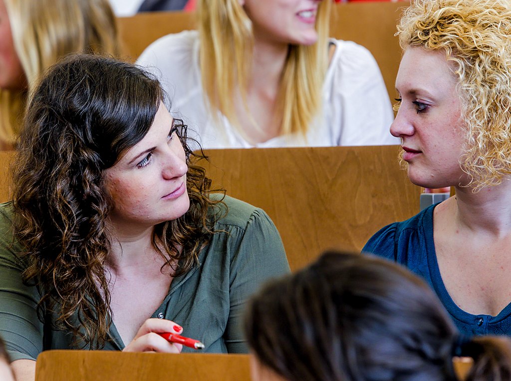 Studierende unterhalten sich im Hörsaal