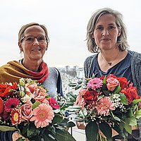 Prof. Dr. Anja Voss und Prof. Dr. Gesine Bär (v.l.n.r.) nach ihrer Wahl mit Blumensträußen auf dem Balkon der ASH Berlin