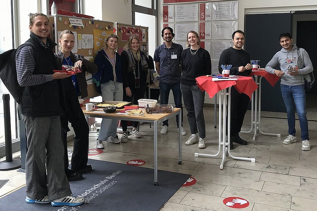 Gruppenfoto vom Team des International Office an einem Infostand im Foyer der ASH Berlin