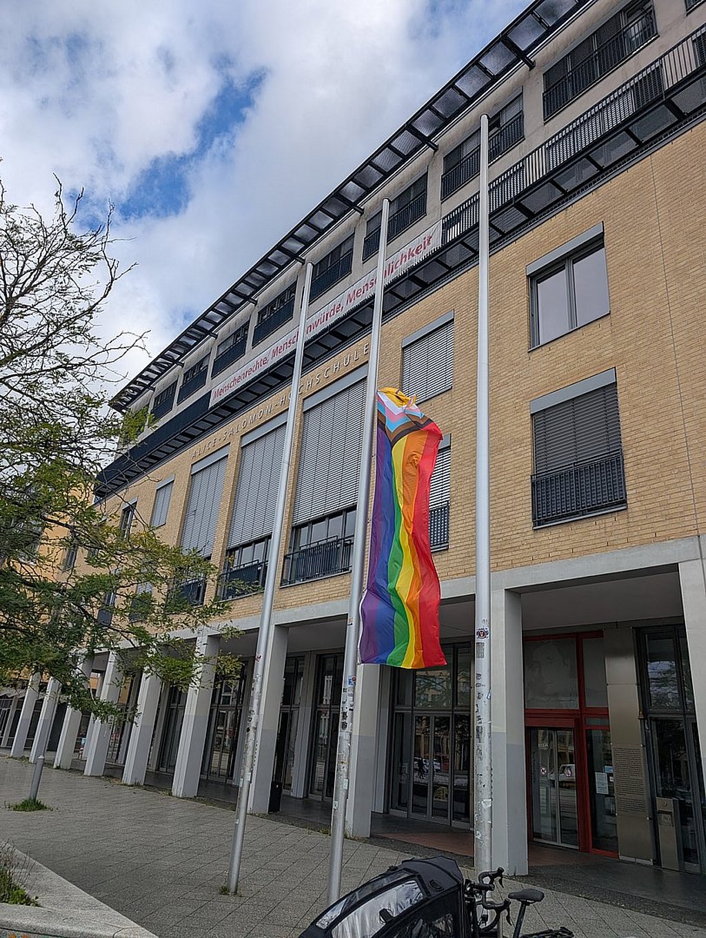 Die Progress-Pride-Flagge weht auf halbmast vor dem Eingang der ASH Berlin