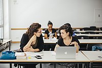 ASH-Studierende sitzen in einem Seminarraum und unterhalten sich