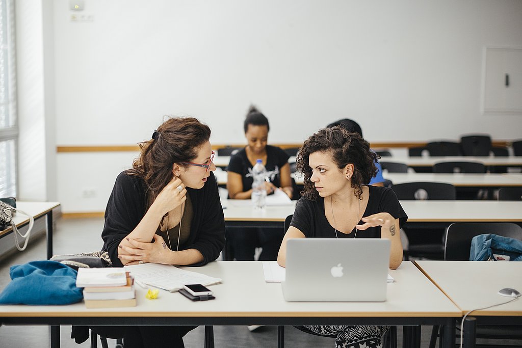 ASH-Studierende sitzen in einem Seminarraum und unterhalten sich