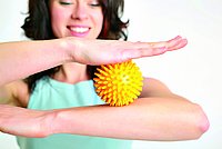 Eine Frau balanciert mit zwei ergotherapeutischen Bällen