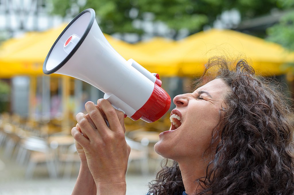Eine Frau schreit in ein Megafon