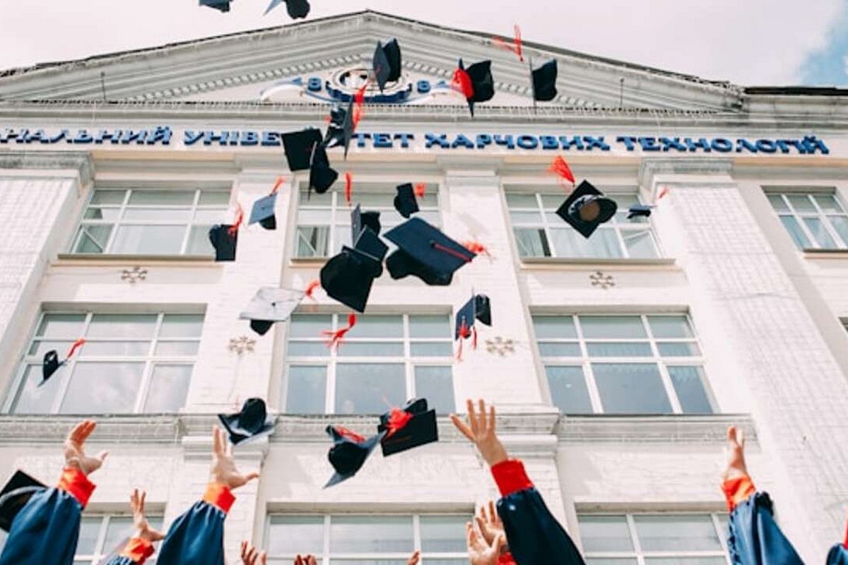 Graduiertenkappen werden in die Luft geworfen