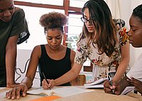 You see four people working together on a text.