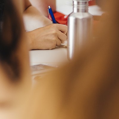 Während eines Seminars macht macht jemand Notizen auf einem Zettel.