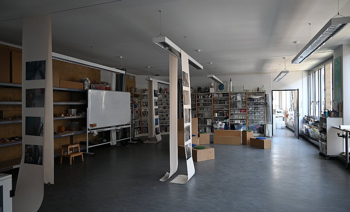 Zu sehen sind mehrere Papierbahnen die im Raum runterhängen.