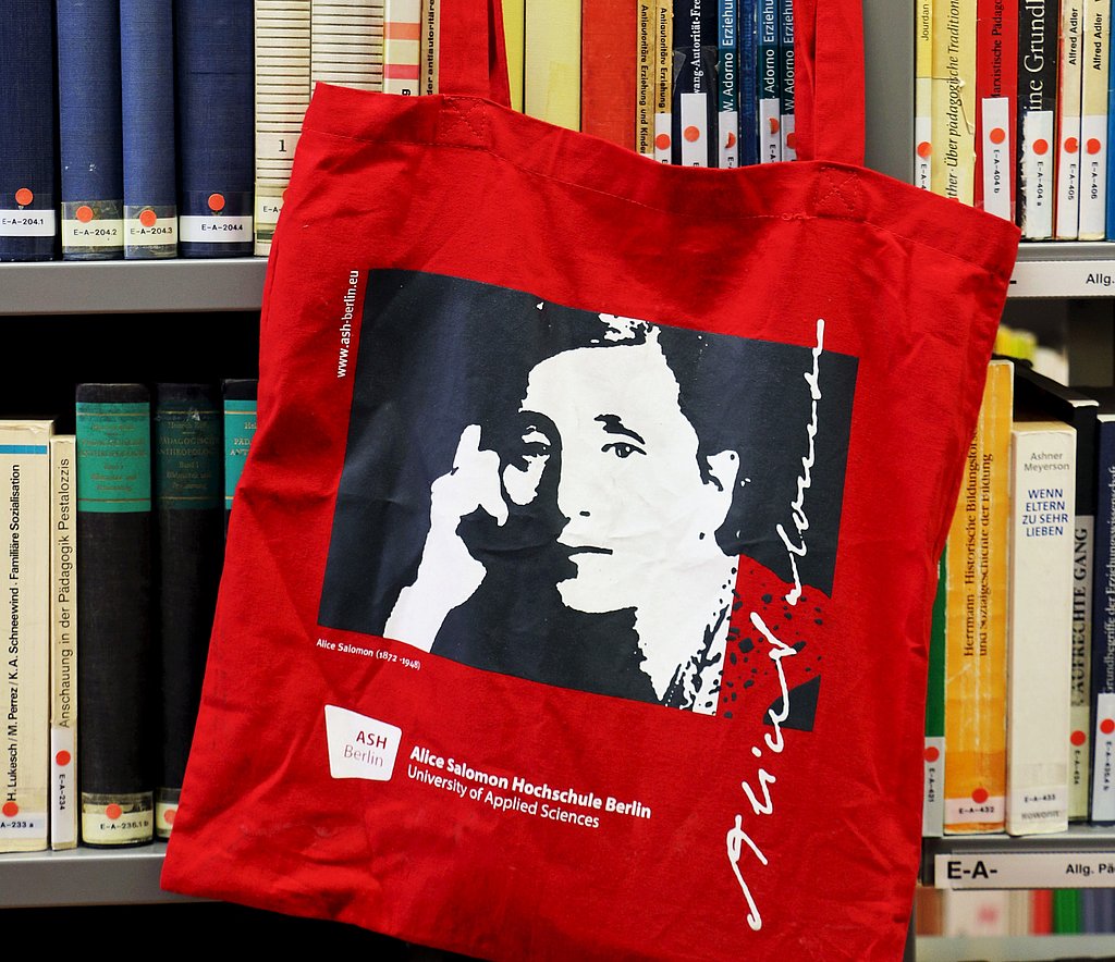 Beutel mit ASH Logo und Bild von Alice Salomon hängt an Bücherregal