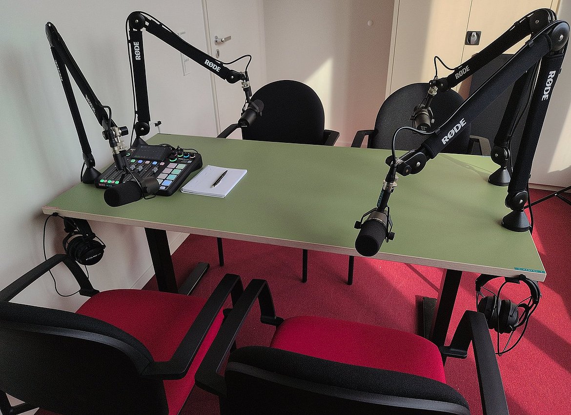 Das Foto zeigt den Podcasttisch im Mediendidaktikraum (K2.27) mit 4 Sprecher_innenplätzen