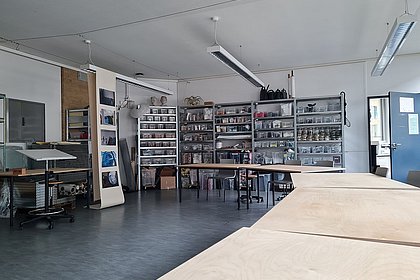 Einblick in den Raum, Perspektive mit Tischen und Materialregalen.