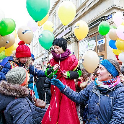 Menschenmenge, Kinder halten bunte Luftballons