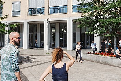 Zwei Studenten laufen dem Hochschulgebäude entgegen.