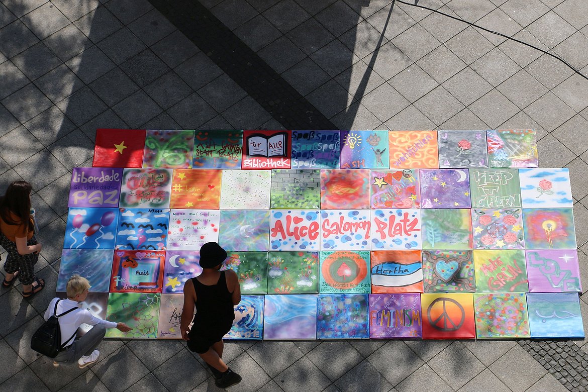 Blick von oben auf Graffitis, die von Teilnehmenden der Beteiligungswerkstatt mein platz | dein platz | unser platz am 7. Juli auf dem Alice-Salomon-Platz gestaltet wurden.