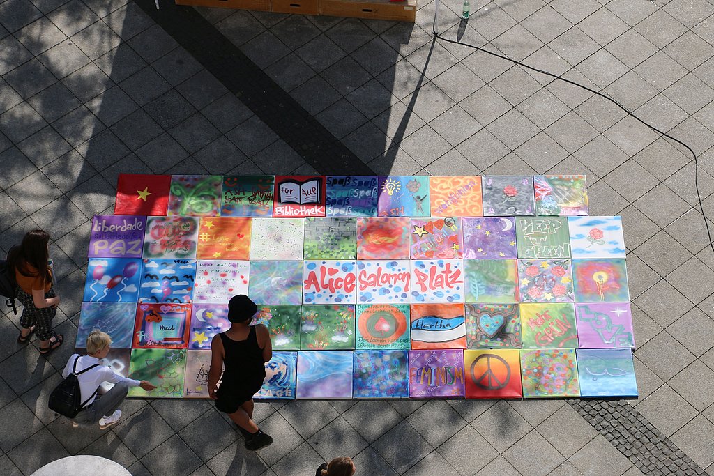 Blick von oben auf Graffitis, die von Teilnehmenden der Beteiligungswerkstatt mein platz | dein platz | unser platz am 7. Juli auf dem Alice-Salomon-Platz gestaltet wurden.