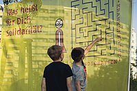 Zwei Kinder vor einem Banner zum Thema Solidarität