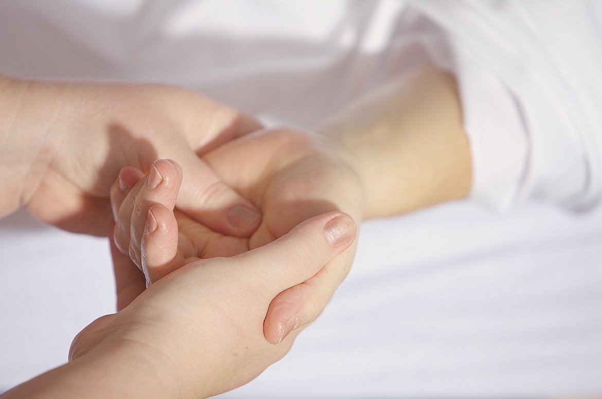 eine Hand massiert eine andere