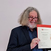 Hans-Ullrich Krause hält seine Ernennungsurkunde in der Hand
