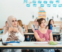 Studierende der ASH Berlin sitzen in einem Seminarraum und hören einem Vortrag zu
