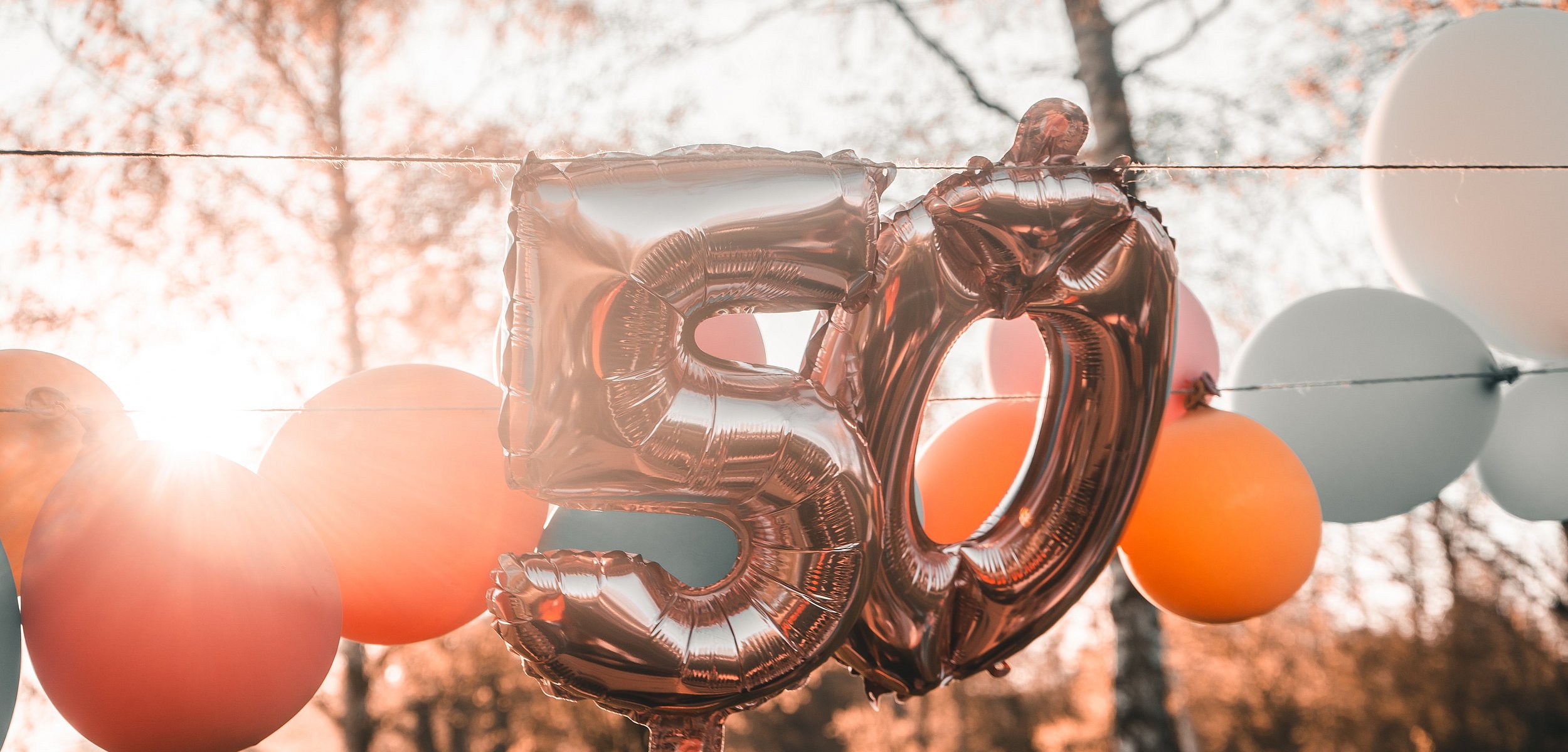 Zahl 50 als Luftballon neben anderen bunten Luftballons