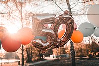 Zahl 50 als Luftballon neben anderen bunten Luftballons