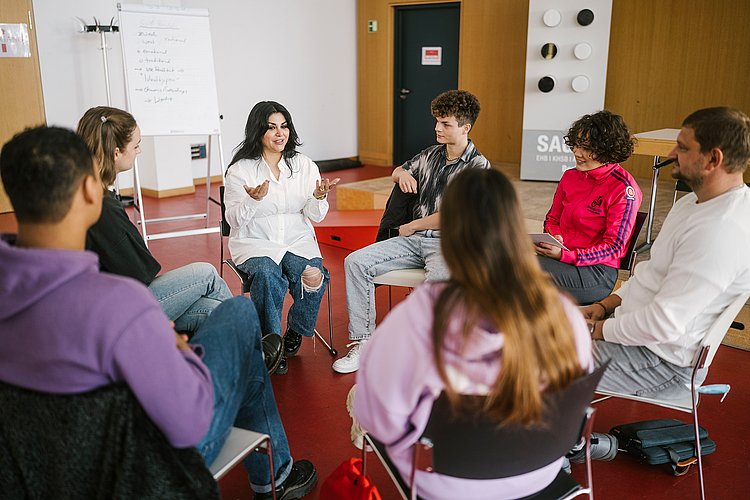 Eine Gruppe von Studierenden diskutiert in einem Stuhlkreis