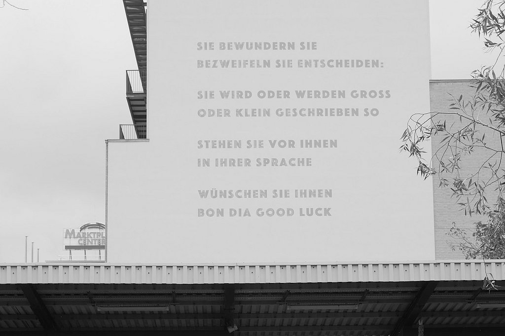 Fassade der ASH Berlin mit Barbara Köhlers Gedicht, darunter der U-Bahnhof