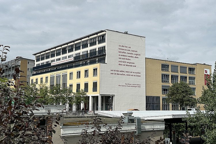 Maxi Obexers Gedicht an der Südfassade der ASH Berlin - davon der Bahnhof und Begrünung