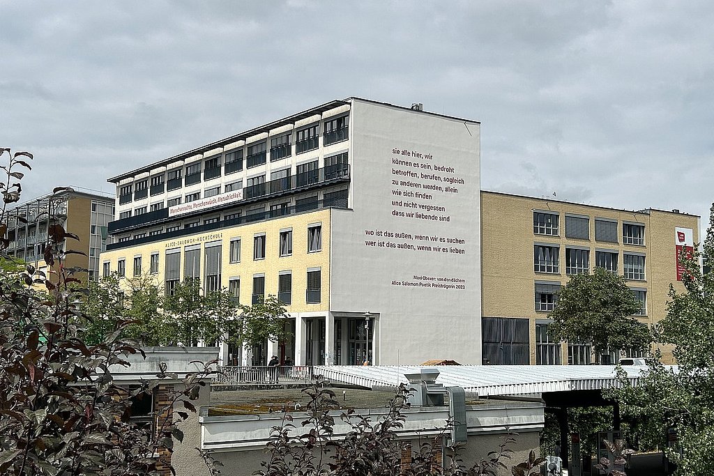 Maxi Obexers Gedicht an der Südfassade der ASH Berlin - davon der Bahnhof und Begrünung