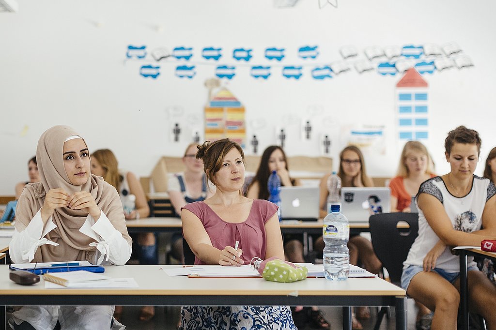 Studierende der ASH Berlin sitzen in einem Seminarraum und hören einem Vortrag zu
