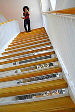 Auf dem Foto läuft eine Studentin die große Haupttreppe im Hochschulgebäude herunter.