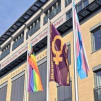 Die Berliner-Anti-Gewalt-Flagge weht zwischen der Progress-Pride und der Trans* Flagge vor dem Hauptgebäude Alice Salomon Hochschule